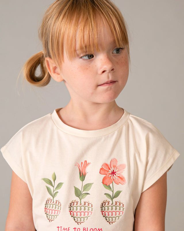 Dettaglio viso bambina con capelli rossi e maglietta floreale