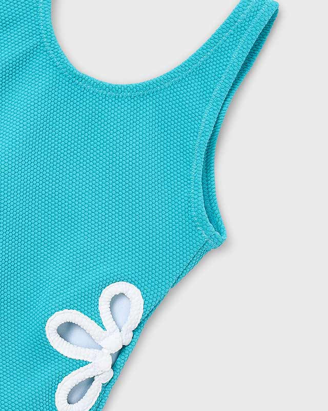 Dettaglio del tessuto del costume da bagno bambina Mayoral celeste con fiore bianco
