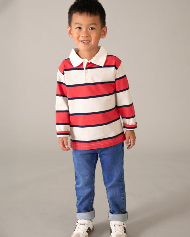 Bambino con jeans e maglia a righe rosse e bianche