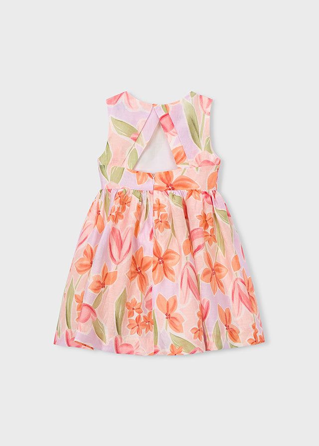 Dettaglio dell'abito cerimonia bambina con fiocco rosa e stampa floreale