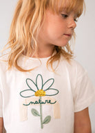 Dettaglio maglietta bambina con fiore ricamato e scritta nature