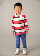 Bambino con jeans e maglia a righe rosse e bianche